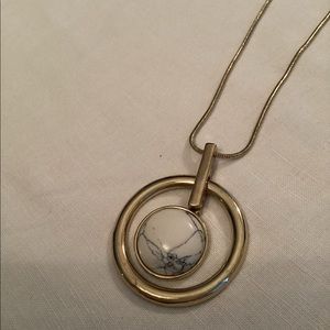 Circle design on a long gold toned snake chain.